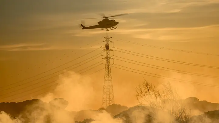Helicóptero MA52 con helibucket junto a una torre eléctrica
