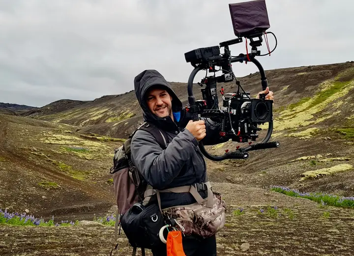 Cámara de cine en gimbal a mano en un paisaje volcánico
